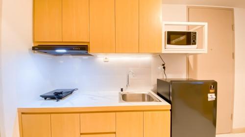 a kitchen with a black refrigerator and a microwave at PIK 2 Tokyo Riverside 2 BEDROOM in Gedong
