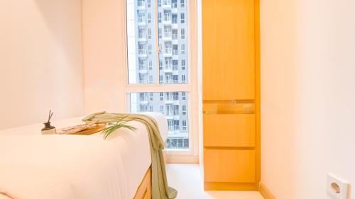 a room with a bed and a window at PIK 2 Tokyo Riverside 2 BEDROOM in Gedong
