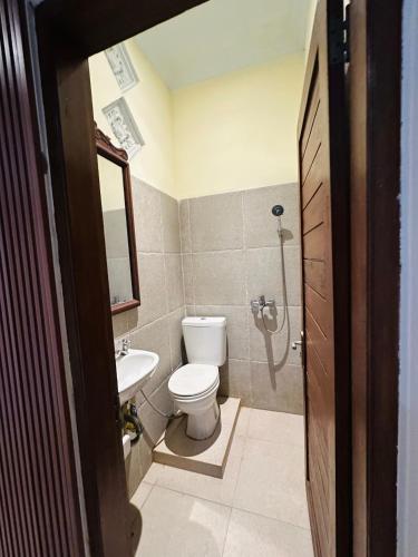 a bathroom with a toilet and a sink at Puri Jumpungan Villas in Sidemen