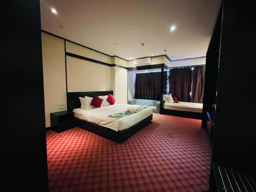 a hotel room with a bed and a red carpet at The Grandeur in Melaka