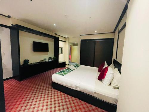 a hotel room with a bed and a television at The Grandeur in Melaka