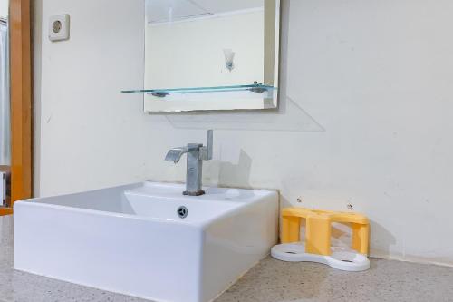 a bathroom with a white sink and a mirror at Urbanview Hotel Dasa Putra Syariah Sumedang in Parakankondang