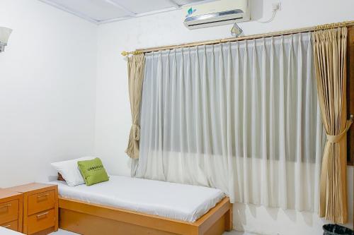 Ένα ή περισσότερα κρεβάτια σε δωμάτιο στο Urbanview Hotel Dasa Putra Syariah Sumedang