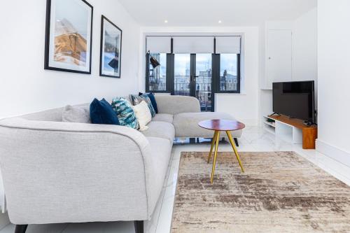 a living room with a couch and a tv at Harley Street Luxury Apartments by City Relay in London