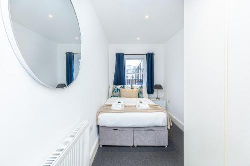 a bedroom with a bed and a mirror at Harley Street Luxury Apartments by City Relay in London