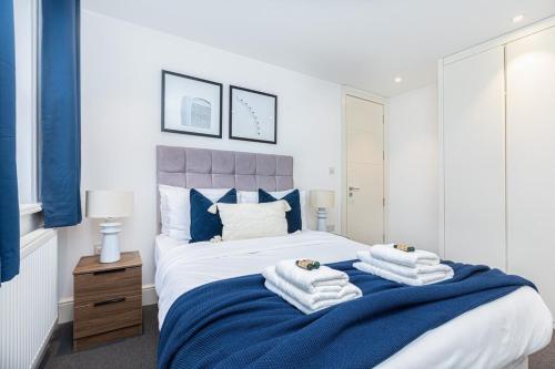 a bedroom with a bed with towels on it at Harley Street Luxury Apartments by City Relay in London