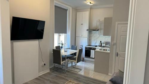 a kitchen with a table and a television on a wall at Modern 2-Bedroom Apartment-Dublin City in Dublin