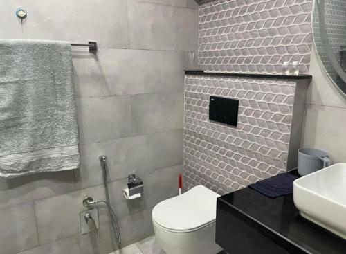 a bathroom with a white toilet and a sink at Royal Villa's DHA in Lahore