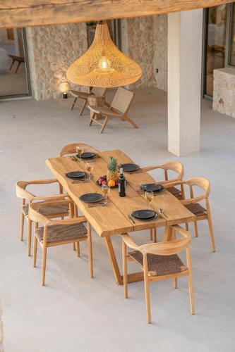 a wooden table with chairs and a light fixture at Lithos Art Villas in Sarlata