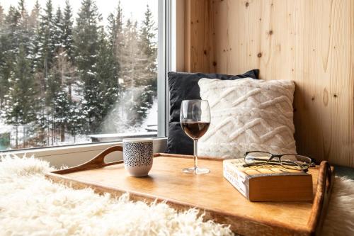 a glass of wine sitting on a table next to a window at Arton Lachtal - Apartments Steiermark in Lachtal