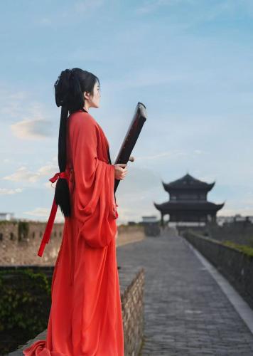 a woman in a red dress standing on a wall with a book at Suzhou Jade Snow Lodge in Suzhou