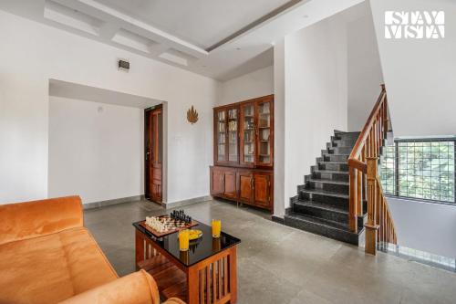 a living room with a couch and a table at StayVista at Misty Village - BBQ, Bonfire & Meals in Pooppara