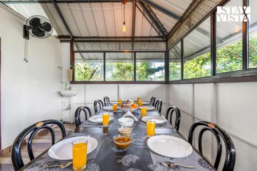 a dining room with a long table and chairs at StayVista at Misty Village - BBQ, Bonfire & Meals in Pooppara