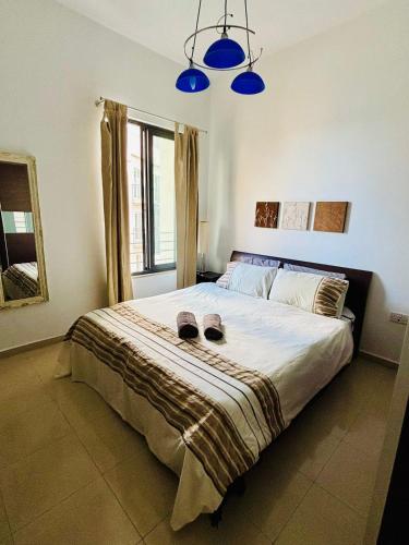 a bedroom with a bed with two slippers on it at Sea side beautiful One bedroom apartment in St Julian's