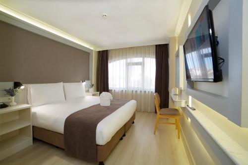 イスタンブールにあるHotel Bulvar Palasのベッドと薄型テレビがあるホテルの部屋