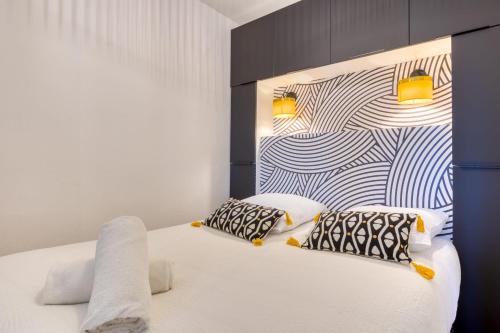 une chambre avec un lit blanc avec deux oreillers dans l'établissement Esmée votre appartement rénové en hyper-centre, à Rouen