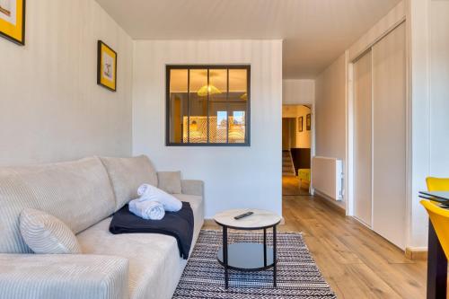 un salon avec un canapé et une table dans l'établissement Esmée votre appartement rénové en hyper-centre, à Rouen