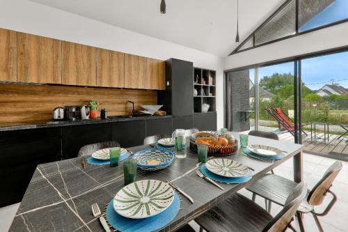une salle à manger dotée d'une table avec des plaques bleues et blanches dans l'établissement À 300m de la plage, belle maison pour 5, à Sarzeau