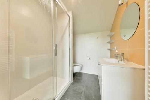 une salle de bain avec une douche, un lavabo et un miroir dans l'établissement À 300m de la plage, belle maison pour 5, à Sarzeau