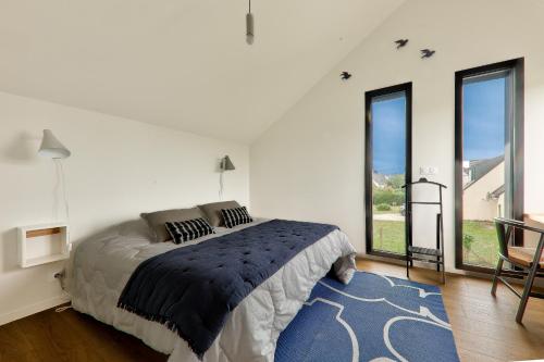 une chambre blanche avec un lit et une grande fenêtre dans l'établissement À 300m de la plage, belle maison pour 5, à Sarzeau