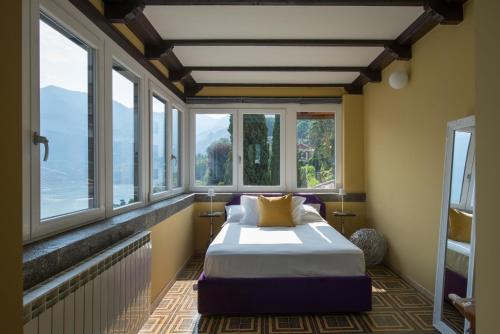 a bedroom with a bed in a room with windows at La Villa Regia in Torno