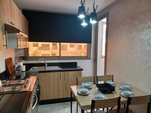 a kitchen with a table and chairs and a kitchen with a sink at Lovely & Comfy Long and Short Stay at Nouacer-Casa 2-Bedroom Apartment in Nouaceur