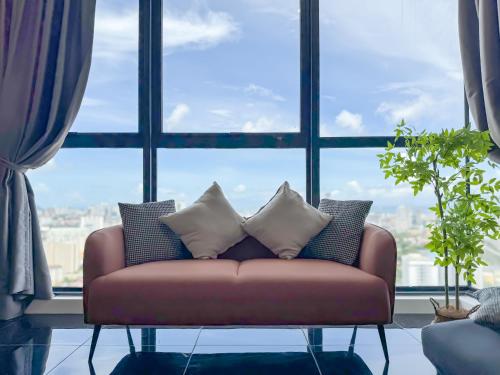 a couch in a room with a large window at Panoramic Georgetown City & Sea View with Netflix in Jelutong