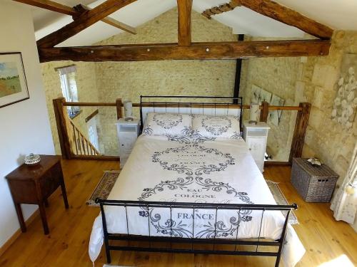 une chambre avec un lit et un parquet dans l'établissement Fresignac, à Saint-Eutrope