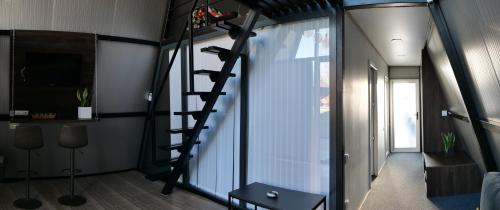 a room with a spiral staircase next to a window at Green Village Pensiune in Roşu