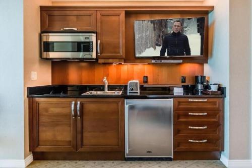 a kitchen with a microwave and a tv on the wall at Strip View Sub-Penthouse 34709 in Las Vegas