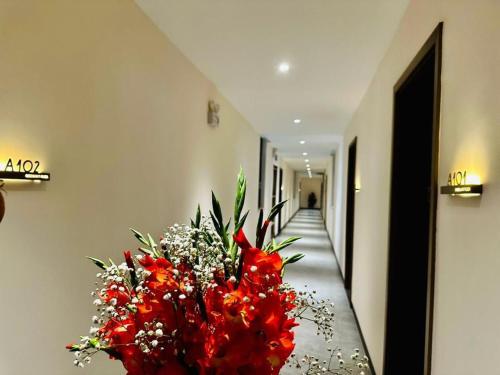 a large vase of red flowers on a hallway at Greenland Apartment by Link in Kigali