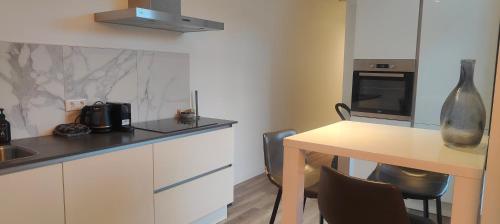 a kitchen with white cabinets and a table with a vase at Eindhoven City Suites Hoogstraat CC Modern 3P in Eindhoven