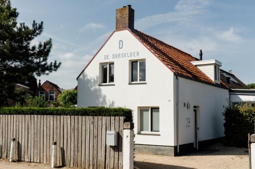a white house with the university written on it at Bed & Bike De Dorsvloer in Domburg