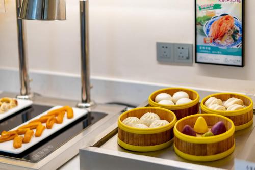 4 recipientes de comida en un mostrador en una cocina en Magnotel Hotel Xi'an Aerospace City Subway Station, en Xi'an