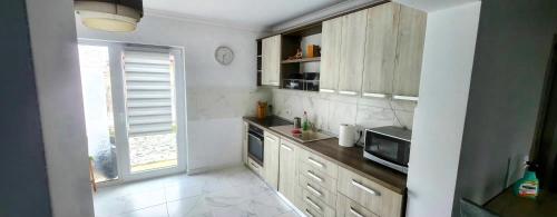 a kitchen with wooden cabinets and a microwave at Casa de inchiriat in Oradea