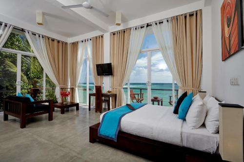 a bedroom with a bed with a view of the ocean at Garton's Cape in Ahangama