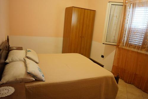 a bedroom with a bed and a window at Loiacono Apartments 2 in Caria