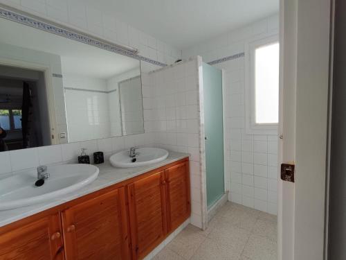 a bathroom with two sinks and a mirror at Villa Victor in Cala en Blanes