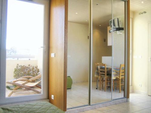 une porte en verre menant à une salle à manger avec une table. dans l'établissement Studio charmant avec vue sur mer à Marseille, 25 m², à Marseille