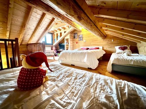 un ours en peluche farci assis au sol d'une chambre dans l'établissement Maison Boule de Neige, meublé de tourisme 3 étoiles, à Formiguères