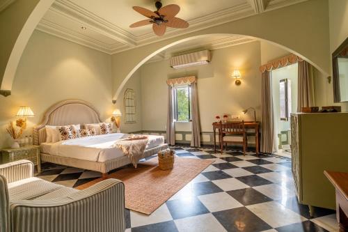 a bedroom with a bed and a checkerboard floor at Daulatgarh Resort in Udaipur
