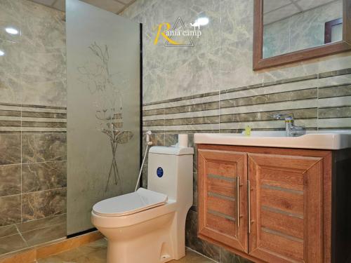 a bathroom with a toilet and a sink at RUM RANIA LUXURU CAMP & Bubbles Hotel in Wadi Rum