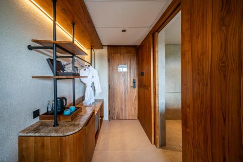 a kitchen with a sink and a hallway with a door at TUI BLUE Berawa Hotel and Villas in Canggu