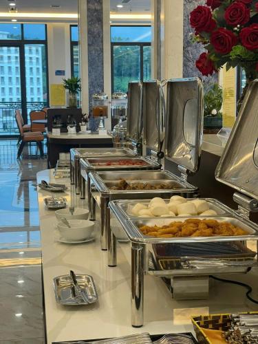 una linea a buffet con vassoi di cibo in esposizione di Kim Sentral Hotel - Travel Agency a Ha Long