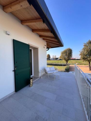 a patio with a green door and a bench at Emilia381 Suite in Anzola dell'Emilia