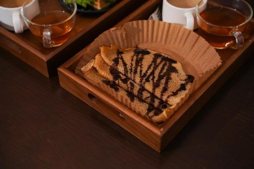 un vassoio di legno con un pezzo di torta su un tavolo di The Upper House Sapa a Sa Pa