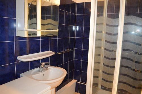 La salle de bains est pourvue de carrelage bleu, de toilettes et d'un lavabo. dans l'établissement Appart 3 pièces 6 couchages BANYULS SUR MER BN020-036, à Banyuls-sur-Mer