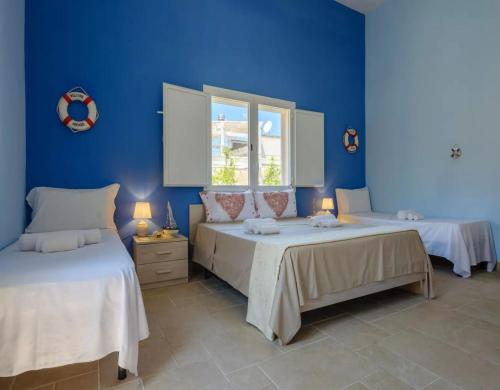 two beds in a room with blue walls at Belvedere Luxury Seafront With Panoramic Terrace in Porto Cesareo