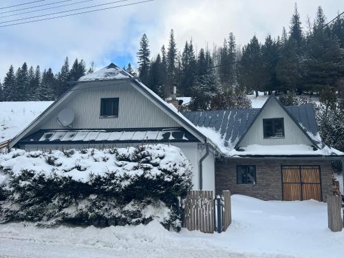a house with snow on the roof of it at WELLNESS Chalet OXY in Ždiar