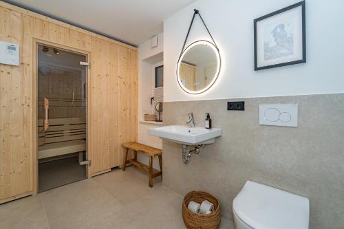 a bathroom with a sink and a toilet and a mirror at Haus Marit in Westerland